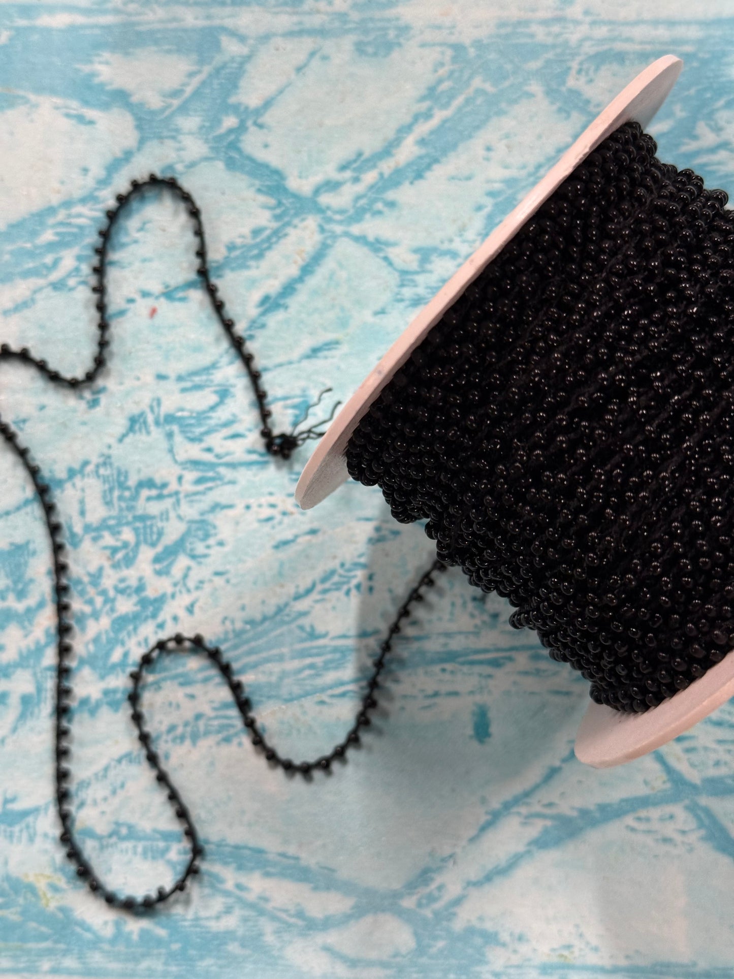 CORD WITH BLACK SEED BEADS PER YARD