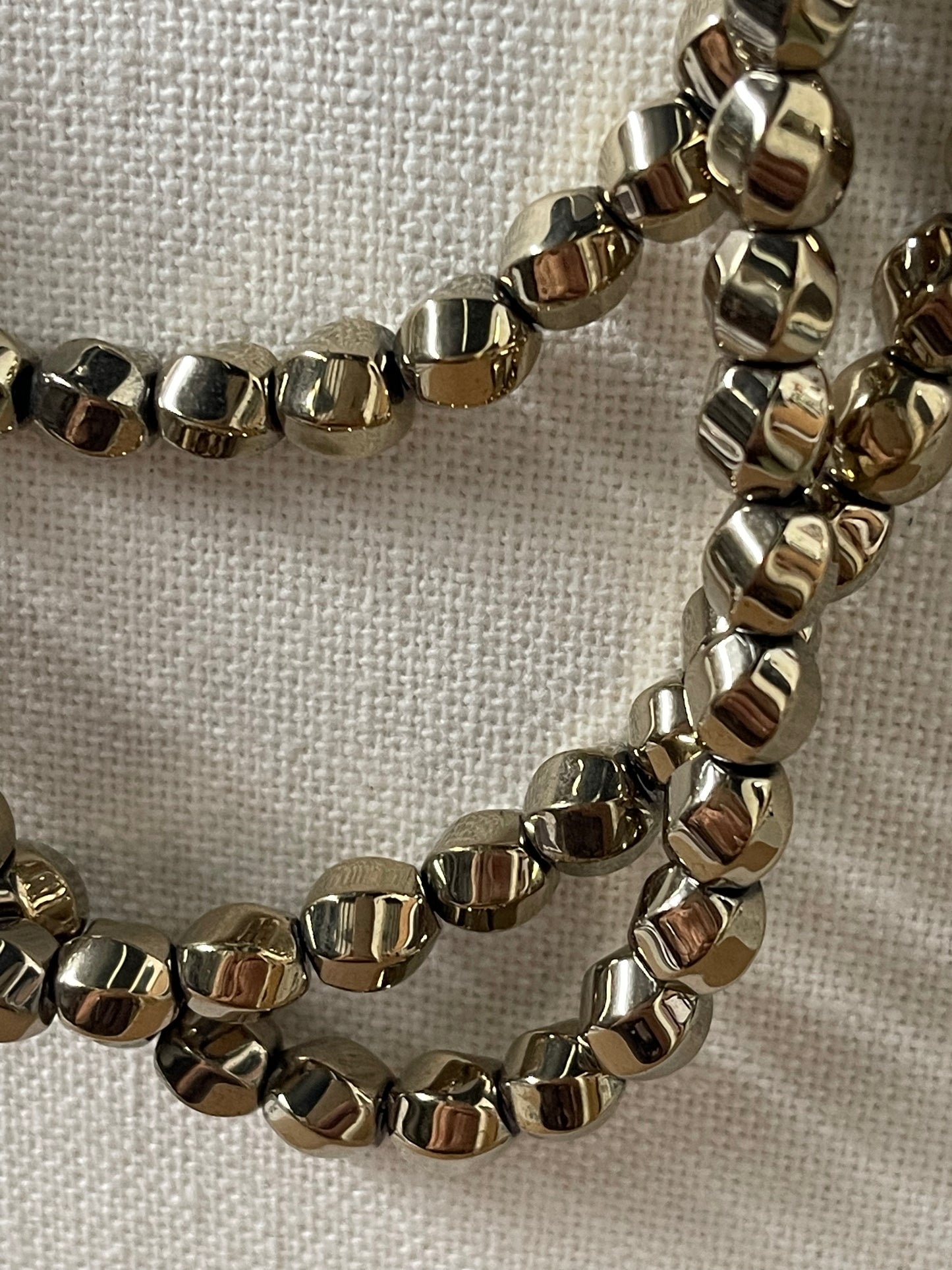 HEMATITE 8X7MM TWIST ROUND LIGHT GOLD PLATE 52 PC PER 1 STRAND
